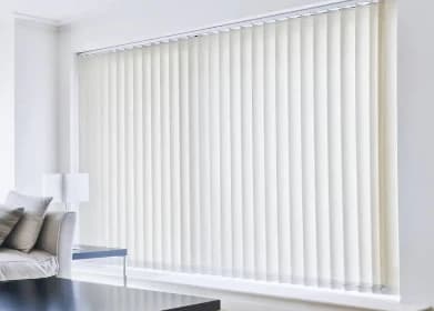 Cream vertical blinds across a wide window